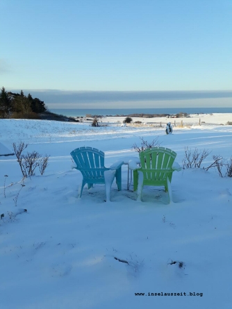 Winterbilder aus Dänemark Insel Møn Gartenstühle im Schnee mit Ausblick auf Ostsee Pension Bakkegaard Møns Klint
